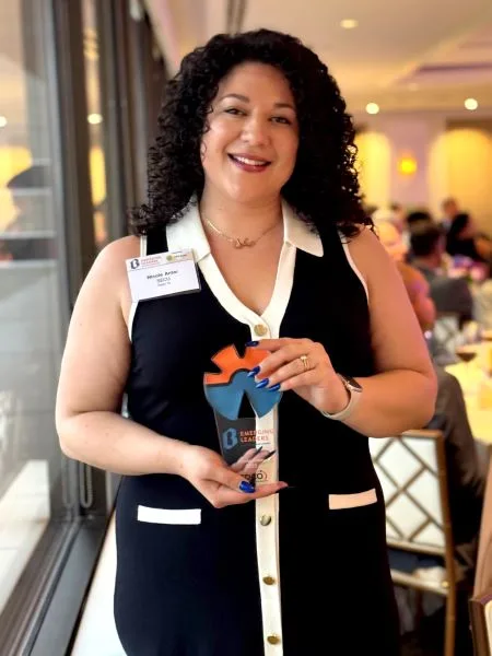 woman in black dress holding an award
