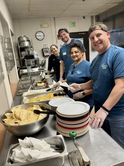 Four people prepare tacos