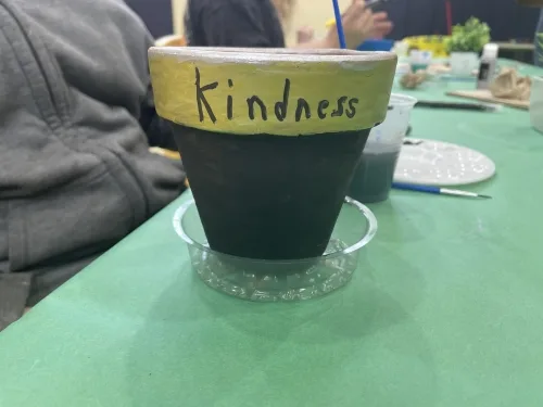 Flower pot with the word "kindness" painted on it