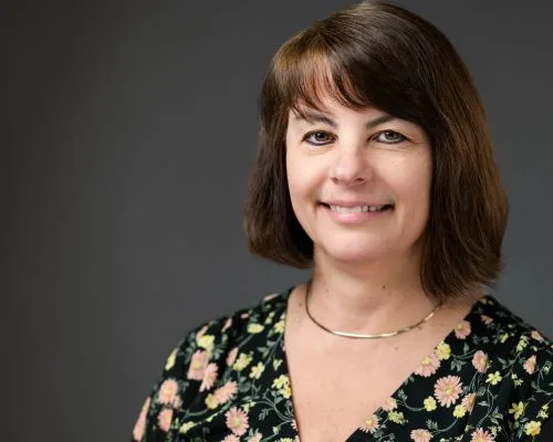 Woman in flowered dress smiles